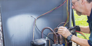 A technician performs brazing on an outdoor AC unit compressor for BV Air Conditioning & Heating in Dallas, TX.