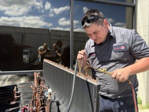 An Interstate AC technician brazing copper lines on an HVAC coil during a repair in Nashville, TN.