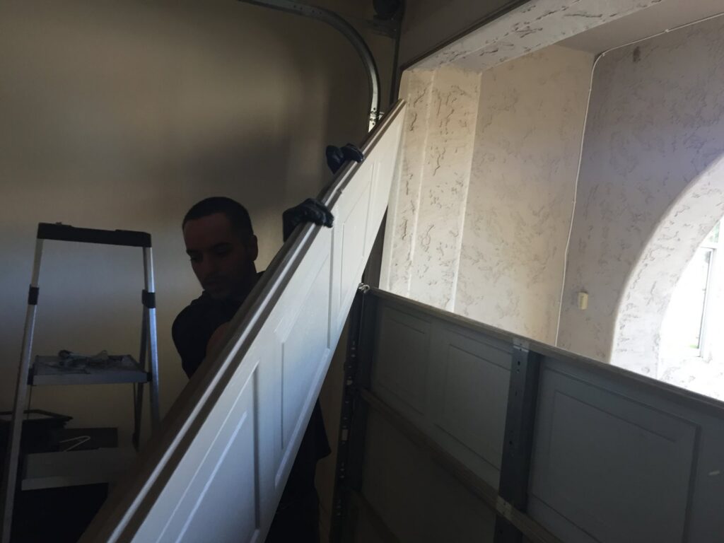 A technician carrying a garage door panel for installation by Nate's Garage Door Repair in Scottsdale, AZ.