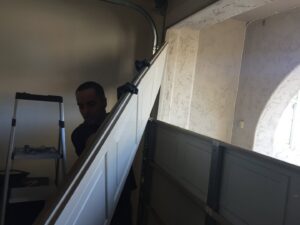 A technician carrying a garage door panel for installation by Nate's Garage Door Repair in Scottsdale, AZ.
