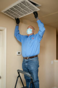 A technician from Eagle Heating & A/C changing an air filter in a home in San Antonio, TX.
