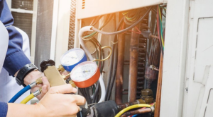 A technician from Rescue Mechanical checking an AC unit with gauges in Rochester, MN.
