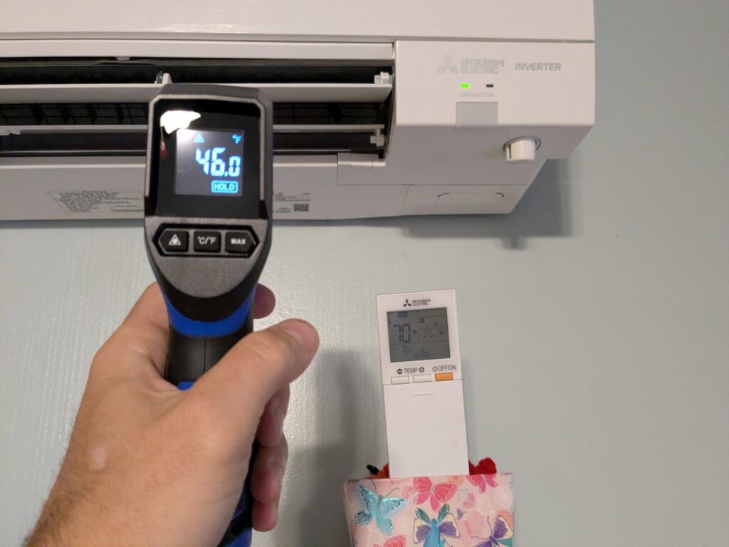 A technician checking mini-split HVAC unit temperature with an infrared thermometer for Gahanna Heating & Cooling in Columbus, OH.
