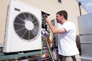 A technician checking an outdoor AC unit with gauges for Daniels HVAC Philadelphia LLC in Philadelphia, PA.