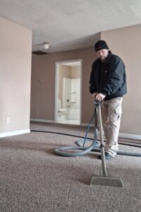 A technician performing professional carpet cleaning with a wand in a room by Advanced Carpet Cleaning in College Station, TX