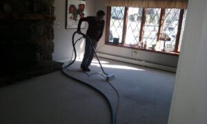 Technician cleaning a light-colored carpet in a living room with professional equipment by Glory Carpet Cleaning Service, East Hartford, CT.