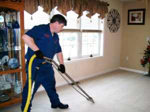 A technician cleaning a light-colored carpet with a professional wand for Magic Carpet Cleaning in Pittsburgh, PA.