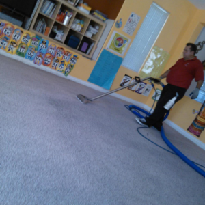 A technician from Molina's Carpet Cleaning actively cleaning a carpet with professional equipment in Las Vegas, NV.