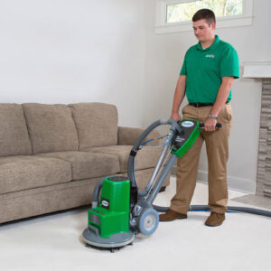 A technician from Precision Chem-Dry Of DFW operating a professional carpet cleaning machine in a living room in North Richland Hills, TX.
