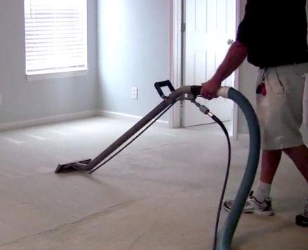 A technician operating a professional carpet cleaning machine in a room, provided by Superior Carpet Cleaning in Greenville, SC.