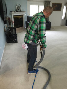 A C&C Carpet Care LLC technician actively cleaning carpet with a professional wand in Columbia, MO.