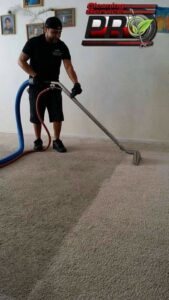 A technician actively cleaning a carpet with a professional wand for Cleaning Service Pro, LLC in Peoria, AZ