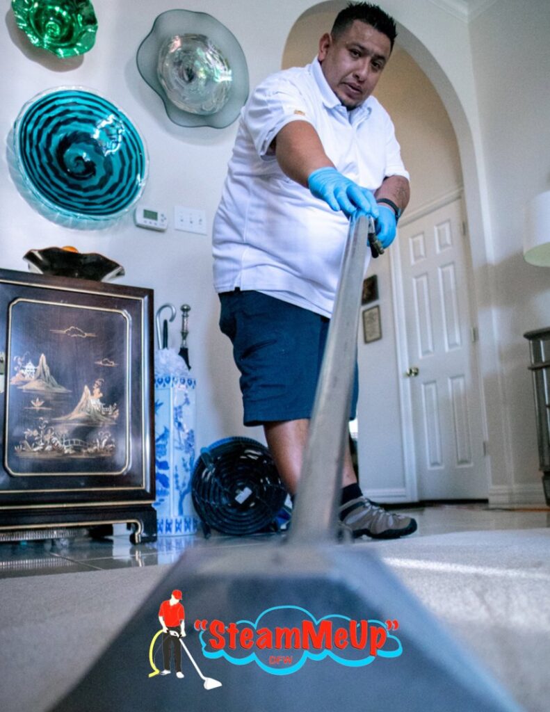 A professional technician using a cleaning wand to deep clean carpet for Steam Me Up Carpet Cleaning in Dallas, TX.