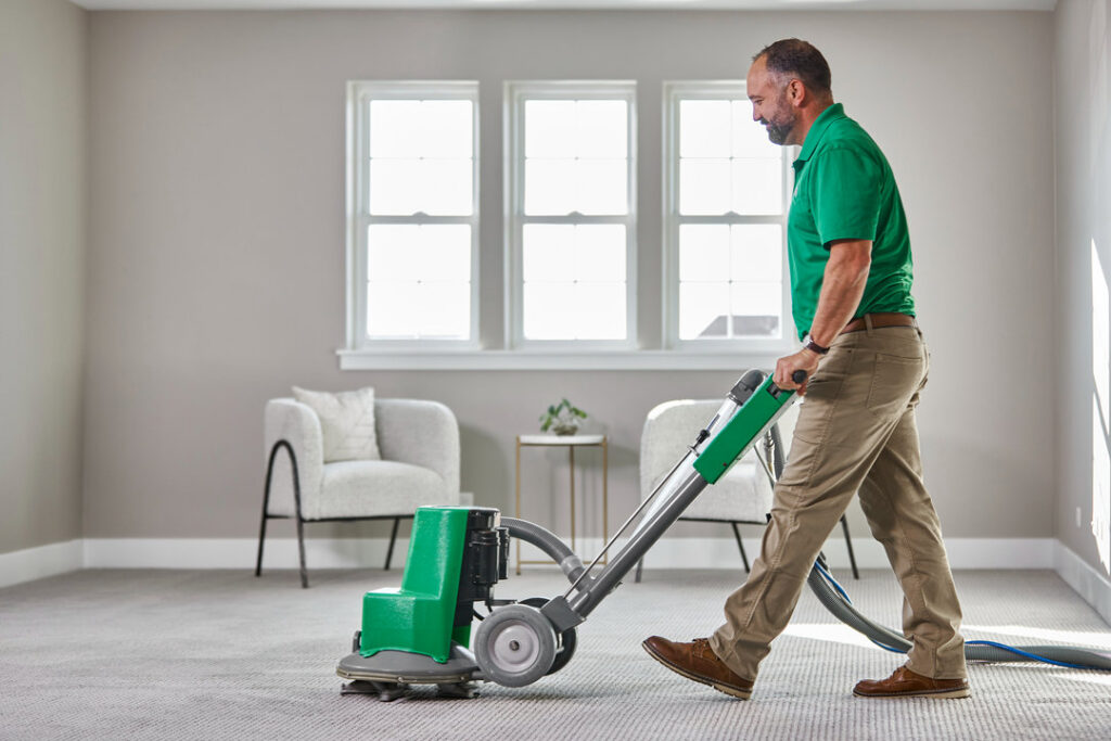 A technician from Brimley's White Glove Chem-Dry operates a carpet cleaning machine on a residential carpet in Mesa, AZ.