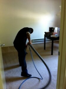 A professional technician cleaning a carpet with a specialized machine for Hillsboro Carpet Cleaning in Hillsboro, OR.