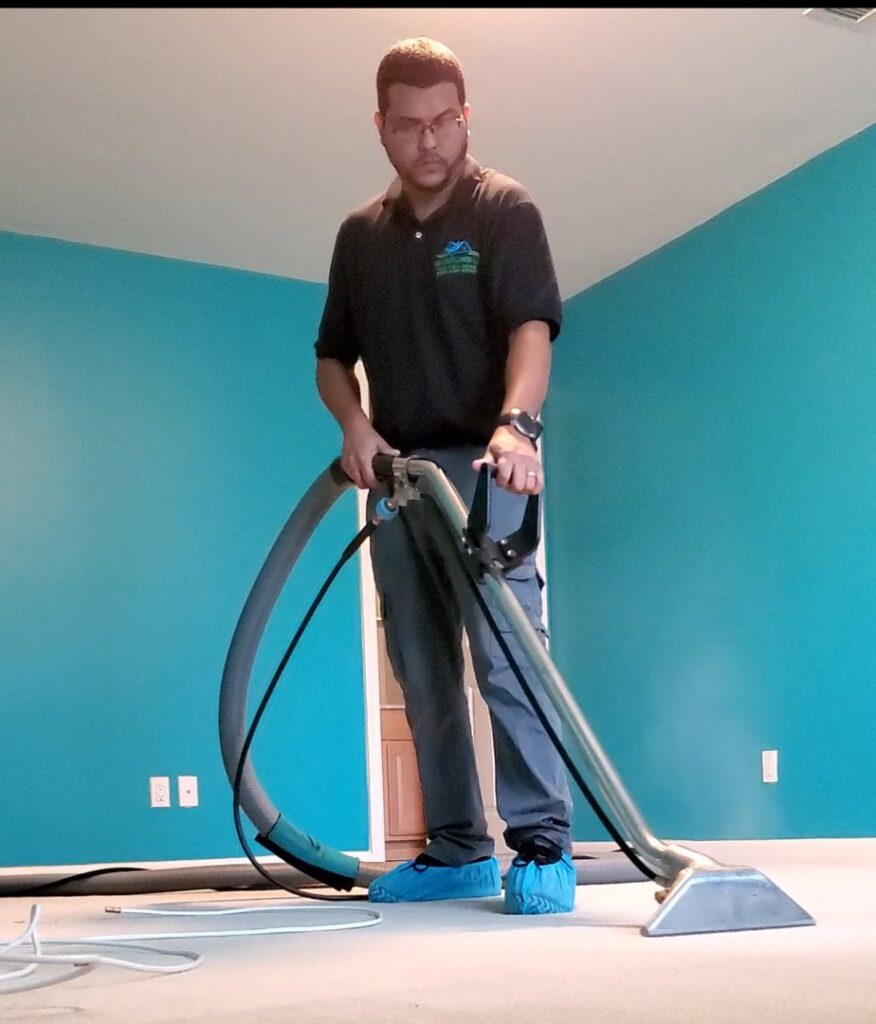 A technician cleaning a carpet with a professional machine for Rise N Shine Cleaning in San Antonio, TX