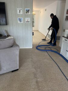 A technician actively cleaning a residential carpet with professional equipment for Soap & Steam Carpet Cleaning in Raleigh, NC