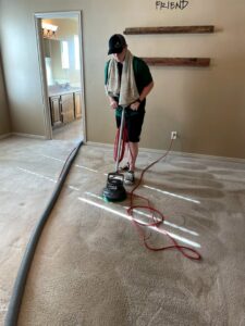 A technician operating a rotary carpet cleaning machine on a residential carpet for Coyote Carpet Cleaning LLC in Bunkerville, NV.