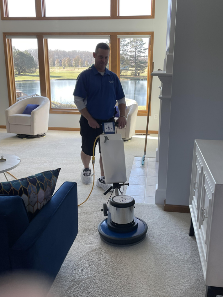 A technician from SM Cleaning Services, LLC cleaning a residential carpet with a rotary machine in Tampa, FL.