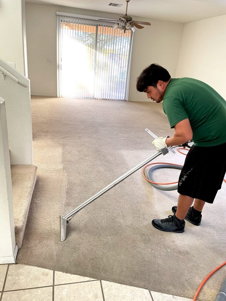 A technician cleaning a residential carpet with a professional cleaning wand for Coyote Carpet Cleaning LLC in Bunkerville, NV.