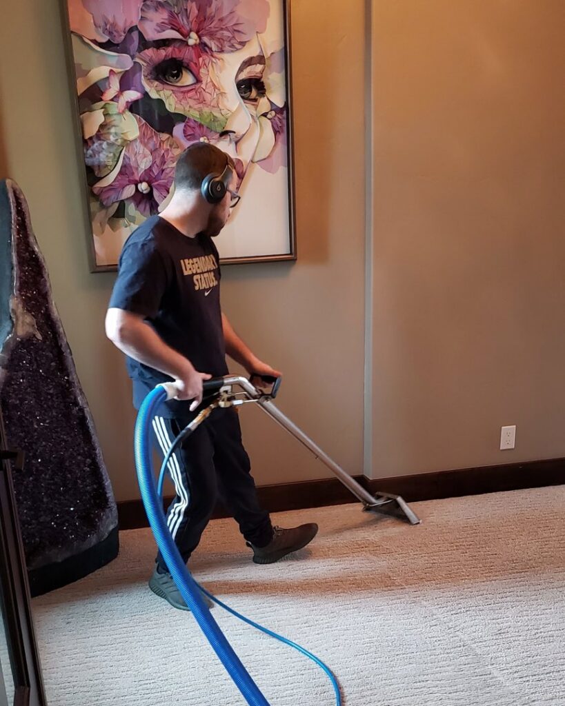A technician professionally cleaning a residential carpet with a cleaning wand for Exceptional Carpet Care in Rochester, MN.