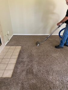 A technician from Raysco, Inc. using a cleaning wand to deep clean a carpet in Las Vegas, NV.