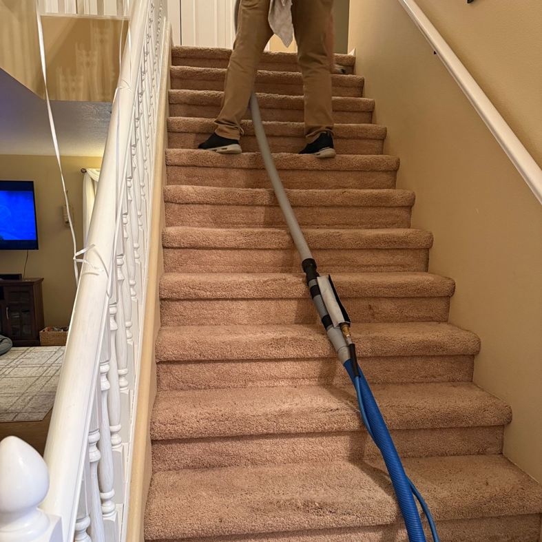 A technician from Heroic Carpet Cleaning Oregon cleaning carpeted stairs with professional equipment in Beaverton, OR