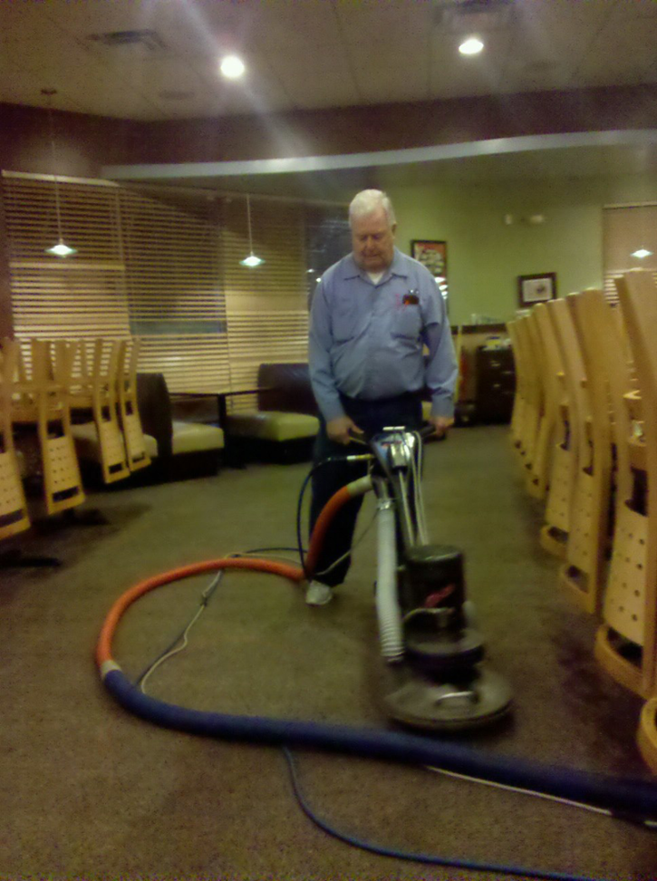 A Duraclean by Barton technician cleaning commercial carpet with a machine in Independence, MO.