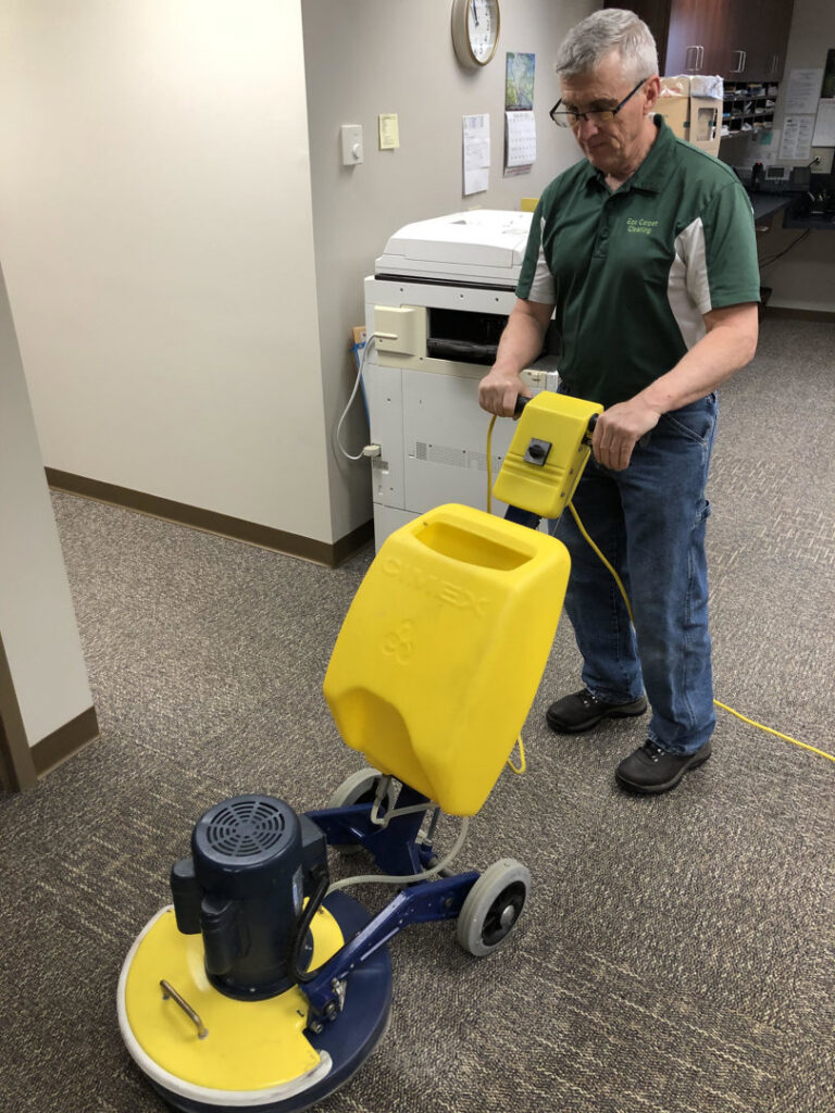 A technician from Eco Carpet Cleaning operating a professional machine to clean commercial carpet in Indianapolis, IN.