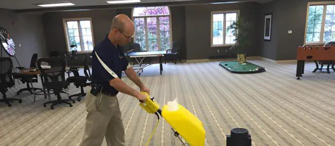 A technician cleaning commercial carpet with a professional machine for Duo-Care Cleaning and Restoration in Sterling Heights, MI