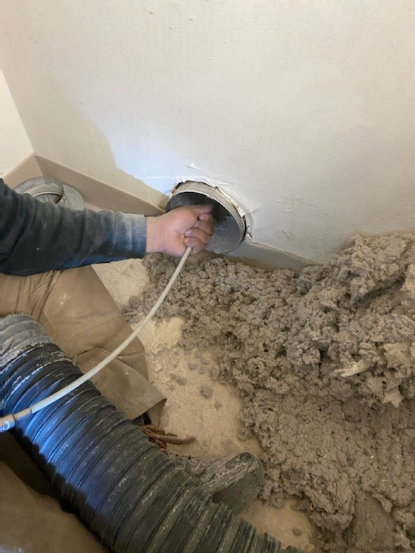 A technician cleaning a dryer vent, showing removed lint and debris, by Wright Way Air Duct Cleaning in Streamwood, IL