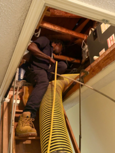 A skilled technician performing air duct cleaning in an attic for Duct Doctor of Baton Rouge, LA.