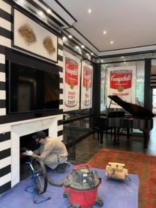 A technician from Chimney Sweep Service LLC cleaning a residential fireplace in Brooklyn, NY.