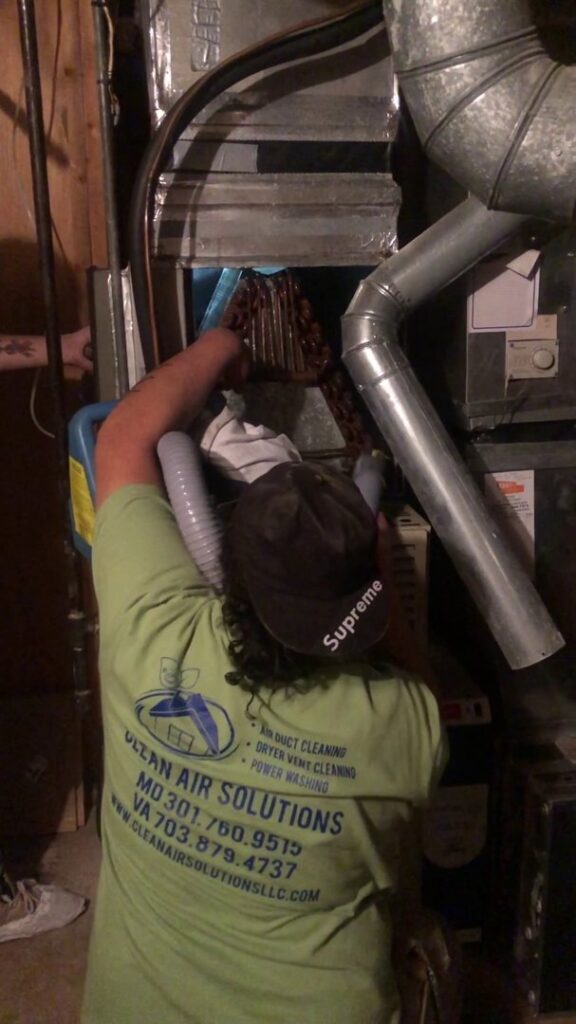 A Clean Air Solutions technician cleaning an HVAC evaporator coil inside a unit in Gaithersburg, MD.