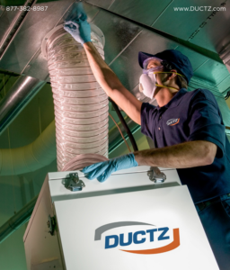 A technician in protective gear cleaning HVAC ductwork for Ductz of Southeast Michigan in Livonia, MI.