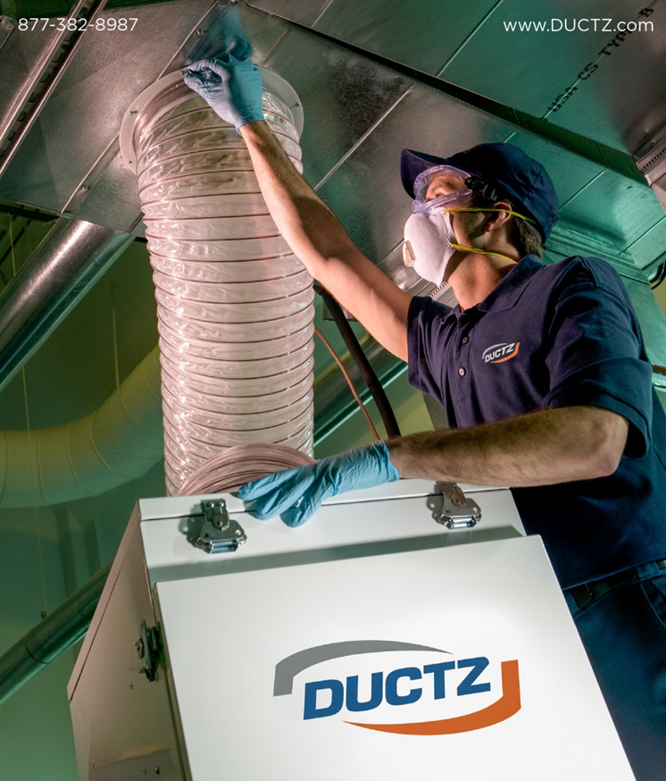 A technician in protective gear cleaning HVAC ductwork for Ductz of Southeast Michigan in Livonia, MI.