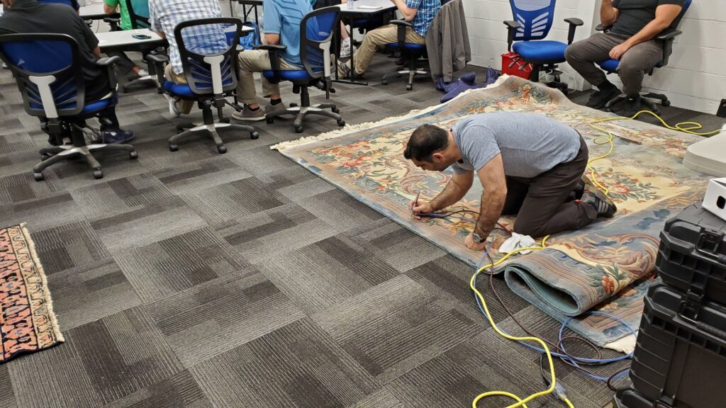 A technician carefully cleaning a large area rug at Rochester Cleanpro in Rochester, NY.