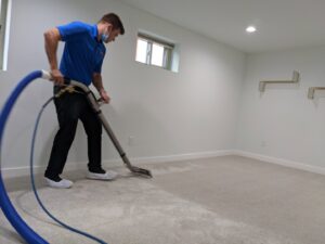 A technician from North Seattle Carpet Cleaning cleaning a light-colored carpet, showing a clean path in Seattle, WA