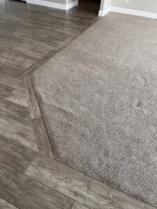 A technician from B's Carpet Cleaning operating a carpet cleaning machine in a residential living room in Saint George, UT.