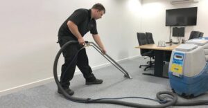 A technician performing professional carpet cleaning in an office setting for Aqualux Carpet Cleaning in Dallas, TX.