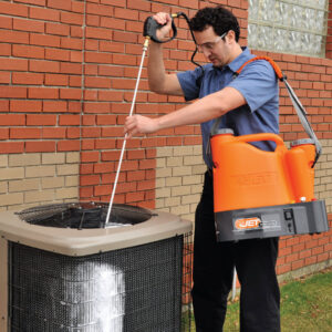 A technician cleaning an outdoor air conditioning unit during maintenance by R&B Cooling&Heating in Abbeville, LA.