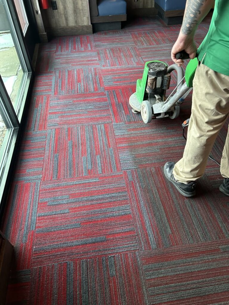 A Chem-Dry of Sioux Falls technician operating a carpet cleaning machine on a patterned commercial carpet in Sioux Falls, SD.