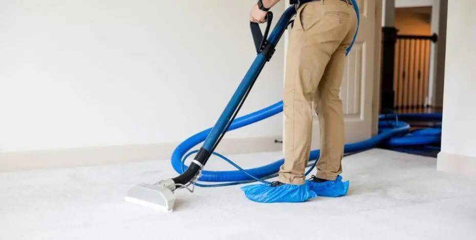 A technician cleaning residential carpet with a professional wand at Duo-Care Cleaning and Restoration in Sterling Heights, MI
