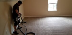 A professional technician cleaning a residential carpeted room with a cleaning wand for Steam Giant in Raleigh, NC.