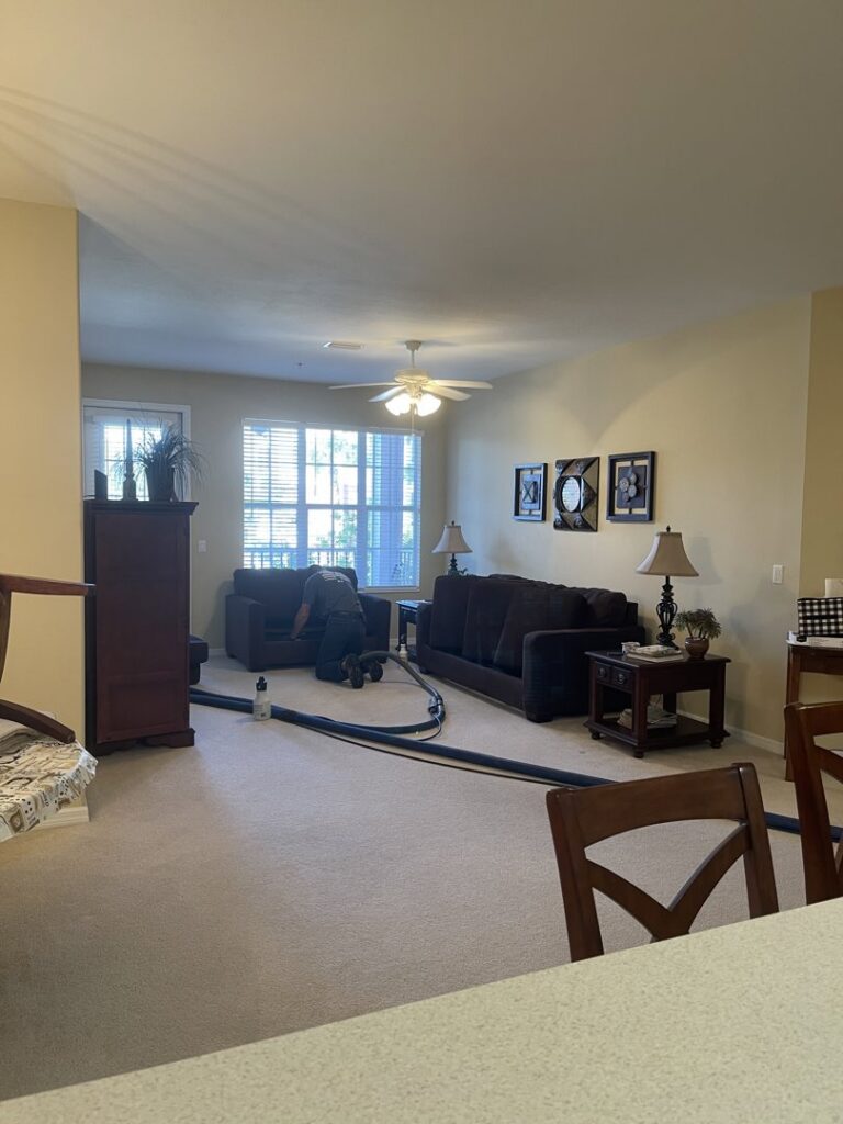 A technician from Captain Steamer performing upholstery cleaning on a sofa in Cape Coral, FL.