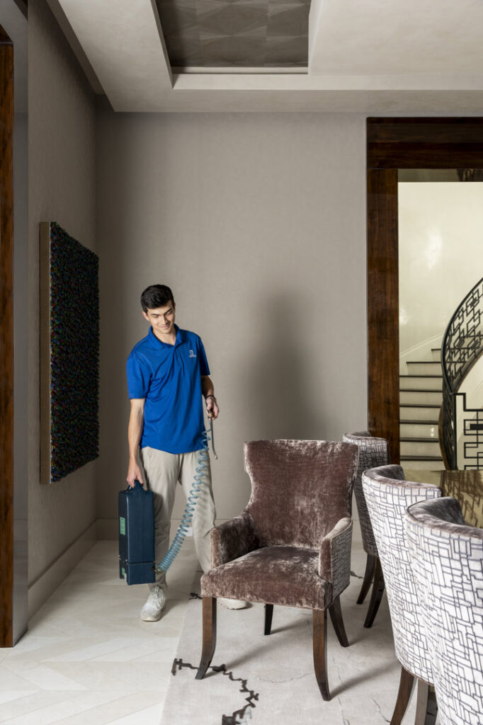 A Fiber-Seal of North Texas technician cleaning upholstery and rug in a home in Dallas, TX