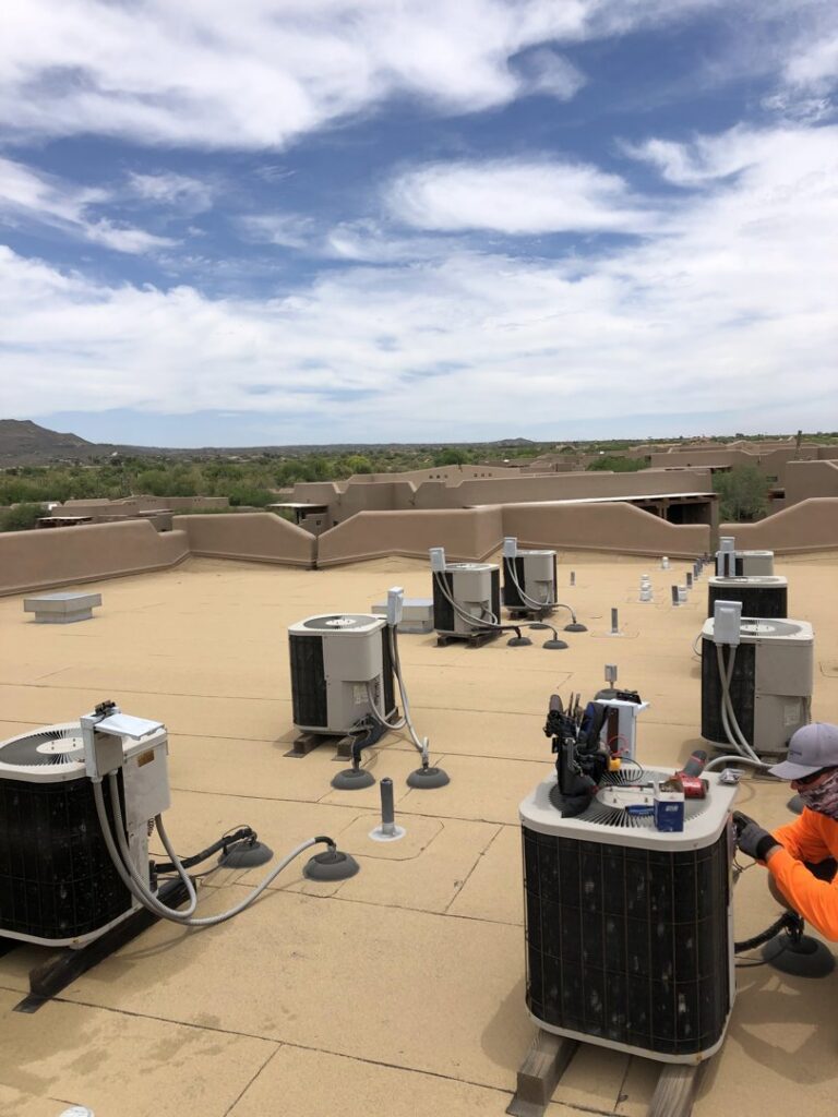 A Mountainside Air technician servicing multiple commercial rooftop AC units in Phoenix, AZ.