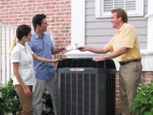 A technician consulting with customers next to an outdoor HVAC unit from Absolute Comfort Heating & Cooling, Inc. in Virginia Beach, VA.