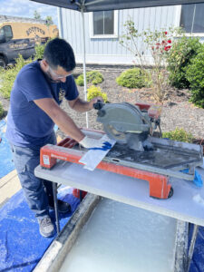 A technician cutting masonry materials with a wet saw for a chimney repair job by Rooftop Chimney Sweeps in Alexandria, VA.