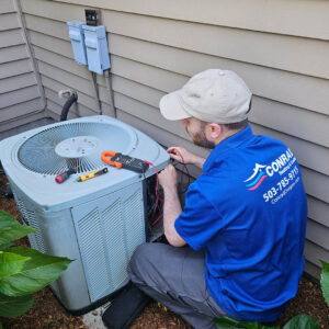 A Conrad Heating and Cooling technician diagnosing an outdoor AC unit with a multimeter in Beaverton, OR.